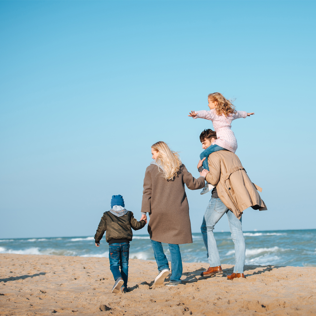 A family walking on the beach on a sunny day. Goal setting that works